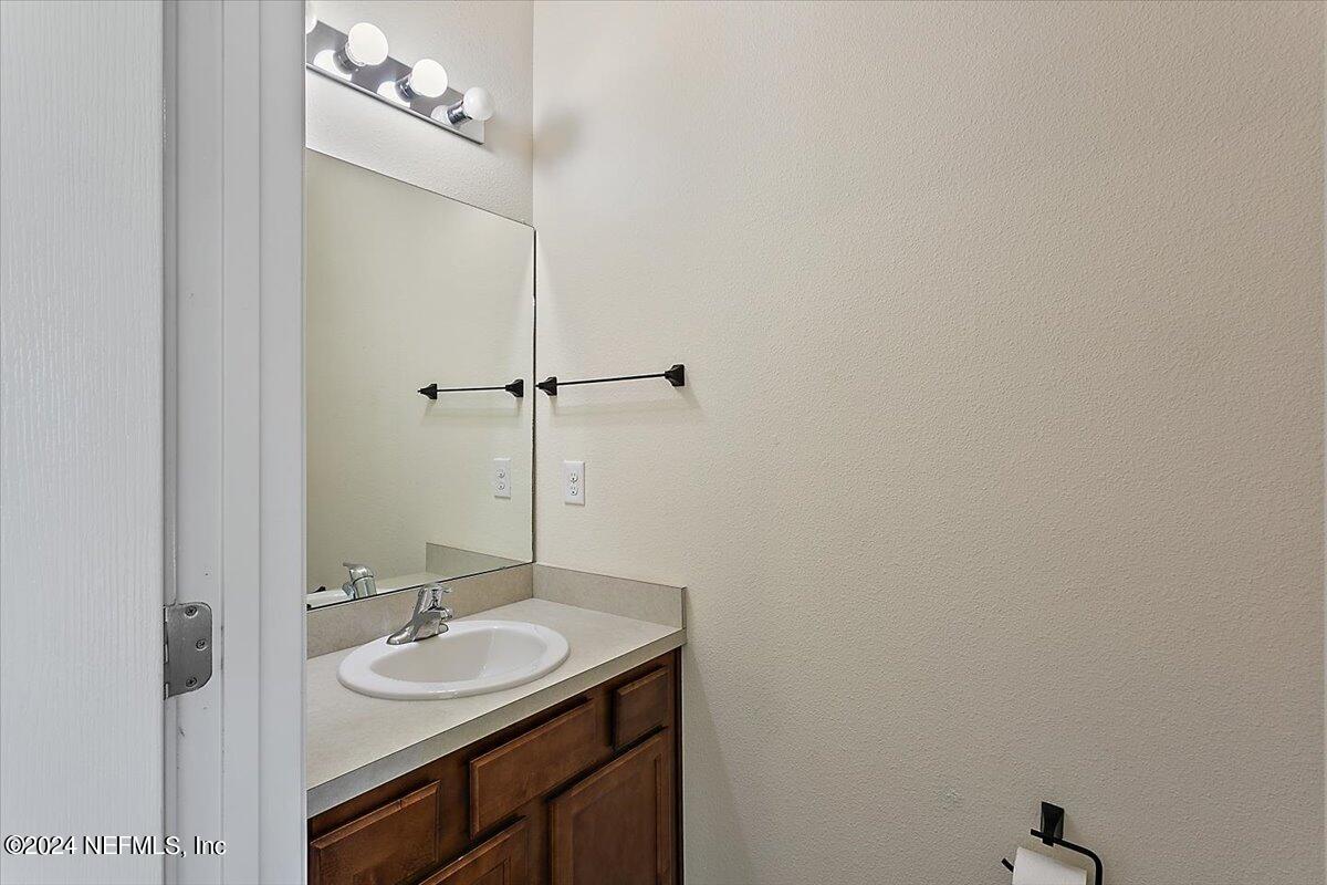 225 Whitland Way St. Augustine, FL 32086 - Photo 15 of 17 a bathroom with a granite countertop sink and a mirror