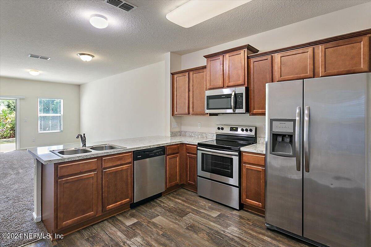225 Whitland Way St. Augustine, FL 32086 - Photo 7 of 17 a kitchen with stainless steel appliances granite countertop a stove a sink dishwasher a refrigerator and a microwave