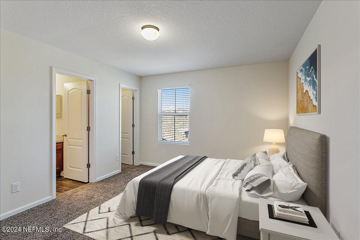 225 Whitland Way St. Augustine, FL 32086 - Photo 10 of 17 a bedroom with a bed and a lamp