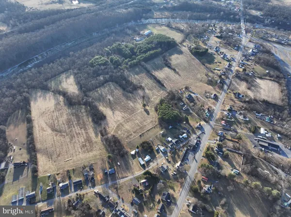 a view of a dry yard with wooden fence