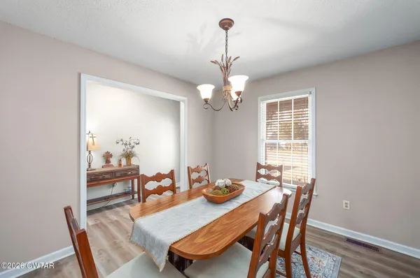a view of a dining room with furniture a chandelier and wooden floor