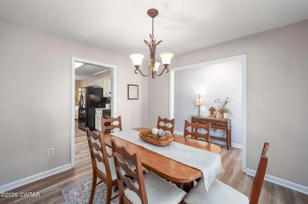a dining room with furniture a chandelier and wooden floor