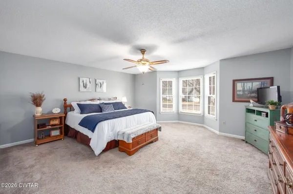 a spacious bedroom with a bed and a cabinets