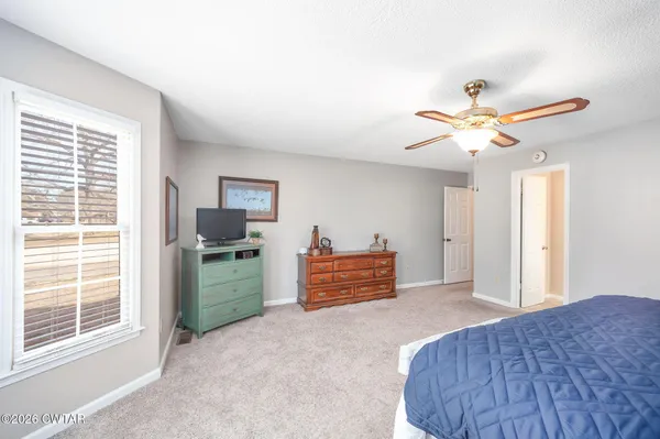 a bedroom with furniture and a ceiling fan