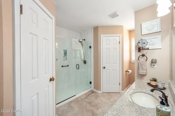 a bathroom with a granite countertop tub sink and mirror
