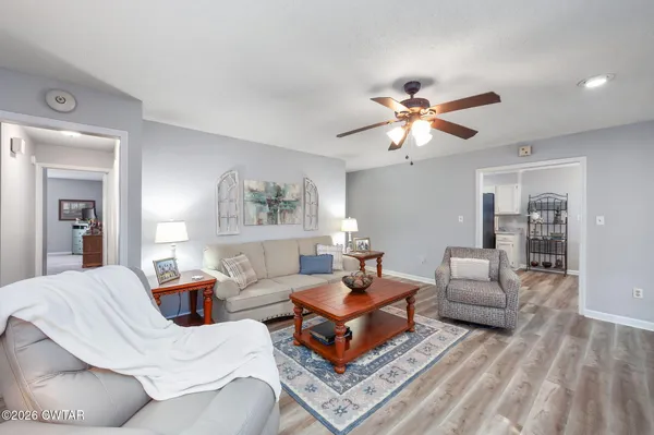 a living room with furniture a chandelier and a rug