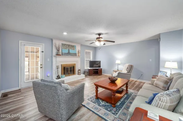 a living room with furniture a fireplace and a flat screen tv