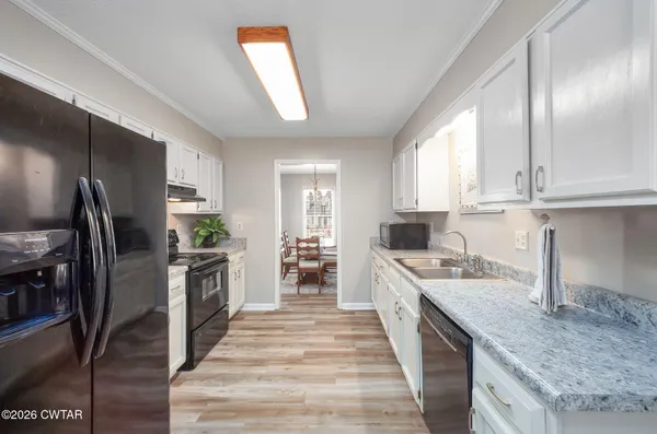 a large kitchen with stainless steel appliances granite countertop a stove refrigerator and cabinets