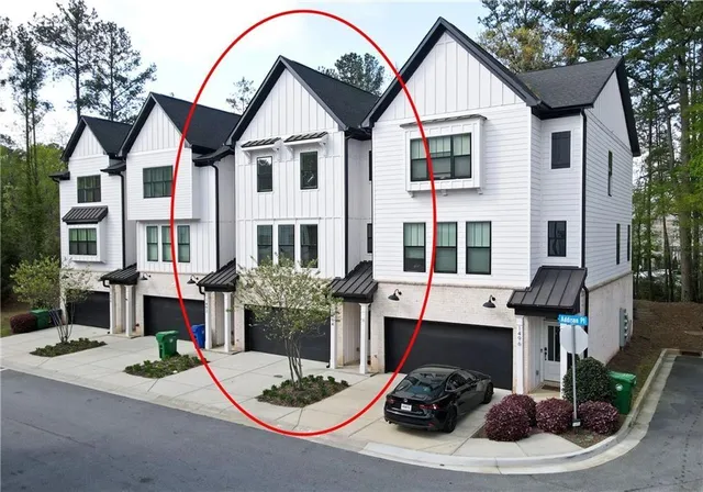 a view of a white house with a sink and a yard