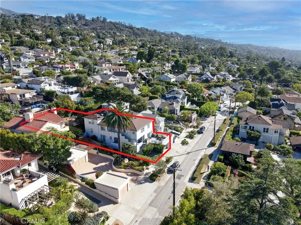 an aerial view of residential houses with outdoor space and trees