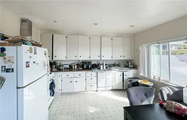 a kitchen with stainless steel appliances granite countertop a refrigerator sink and white cabinets