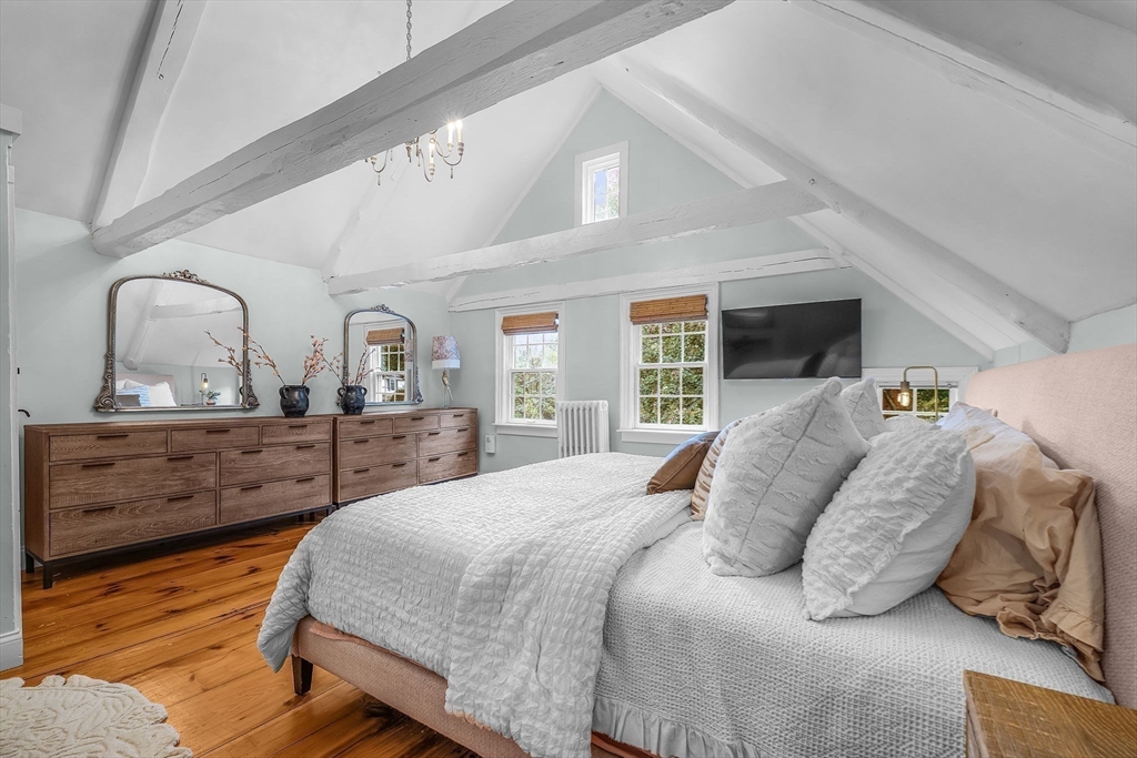 180 Elm Street Hanover, MA 02339 - Photo 21 of 30 a bedroom with a large bed and wooden floor