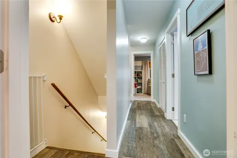 a view of a hallway with wooden floor and staircase