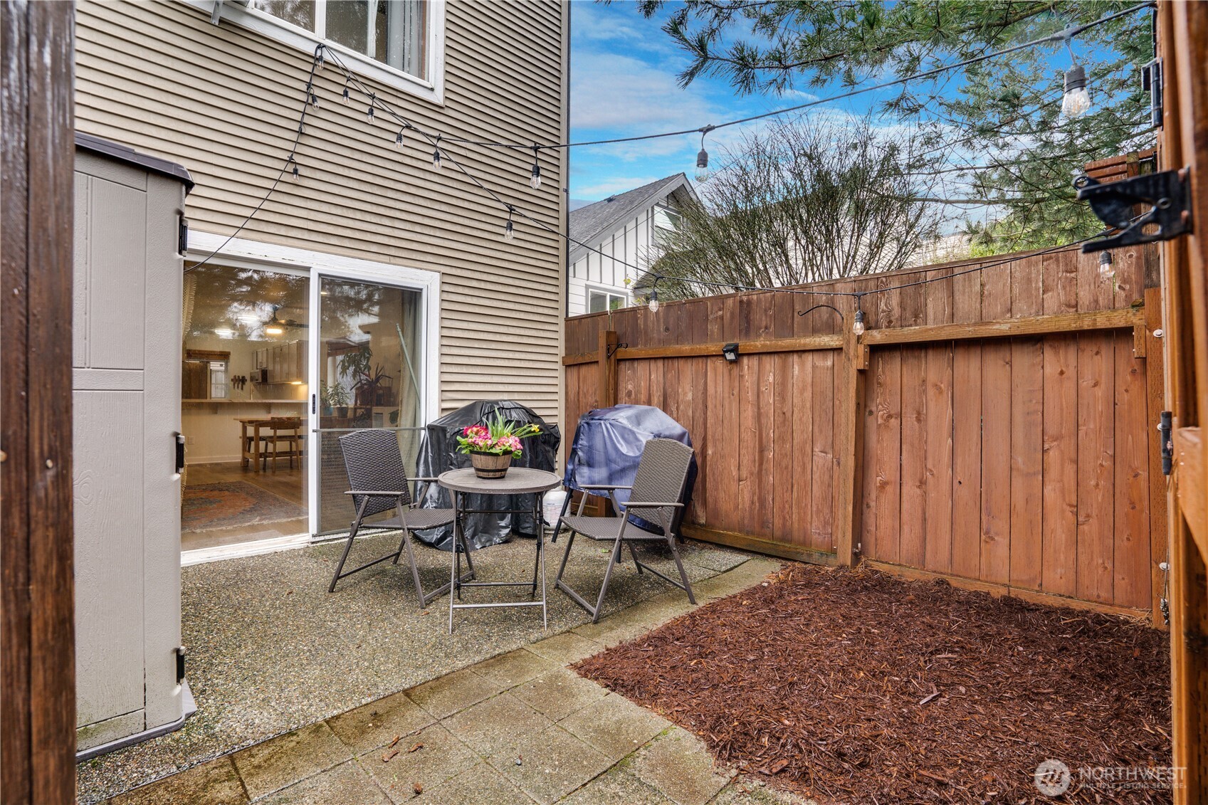 10319 Midvale Avenue North, Unit A Seattle, WA 98133 - Photo 30 of 34 a view of a patio with a table and chairs and potted plants