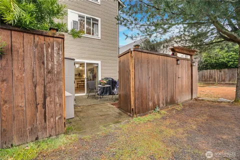 a view of a house with backyard and wooden fence