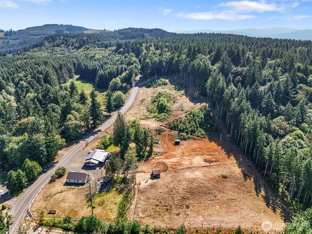 an aerial view of a house with a yard and mountain