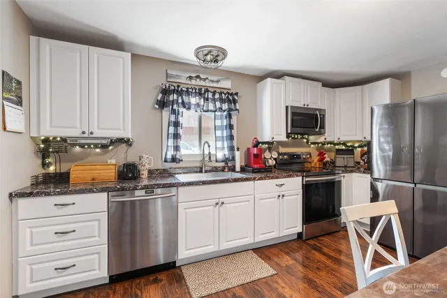 a kitchen with stainless steel appliances granite countertop a stove a sink dishwasher a refrigerator and a microwave