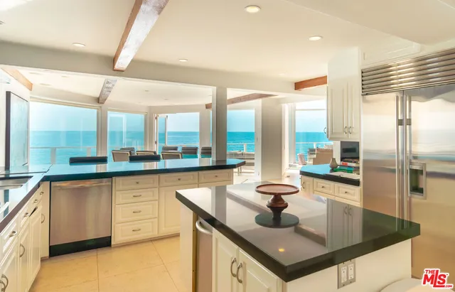 a kitchen with stainless steel appliances granite countertop a sink a stove and a refrigerator