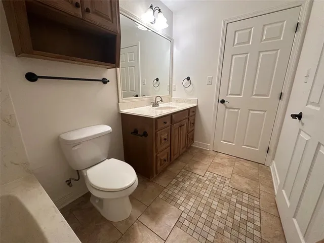 a bathroom with a toilet a sink a mirror and vanity