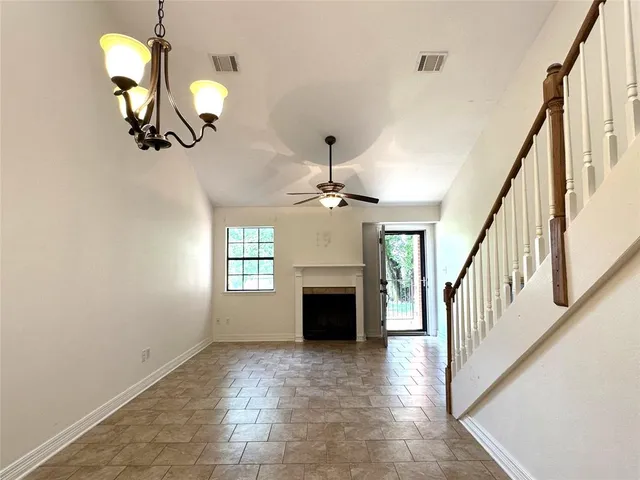 a view of a livingroom with a fireplace wooden floor and chandelier
