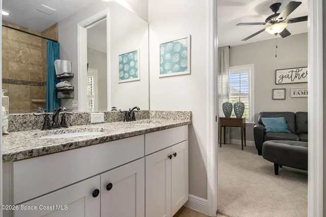 a en suite bathroom with a granite countertop sink and a mirror