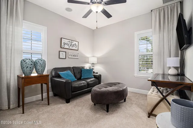 a living room with furniture a flat screen tv and a window