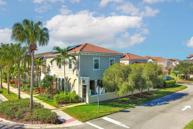 a front view of a house with a yard and potted plants