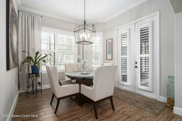 a dining room with furniture a chandelier and wooden floor