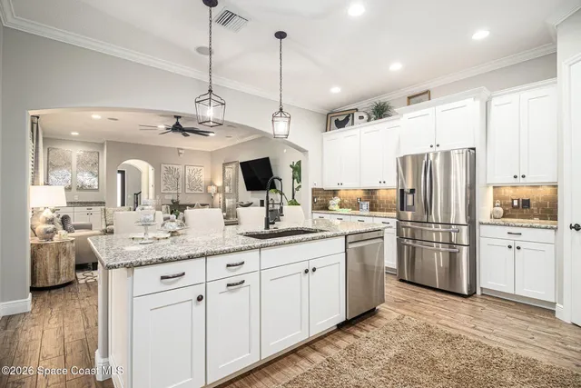 a kitchen with kitchen island granite countertop stainless steel appliances and wooden floor