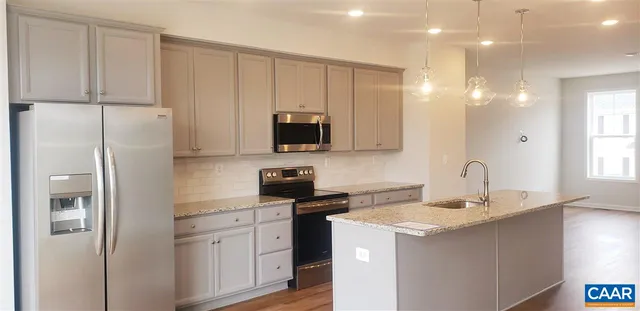 a kitchen with a sink a refrigerator and cabinets