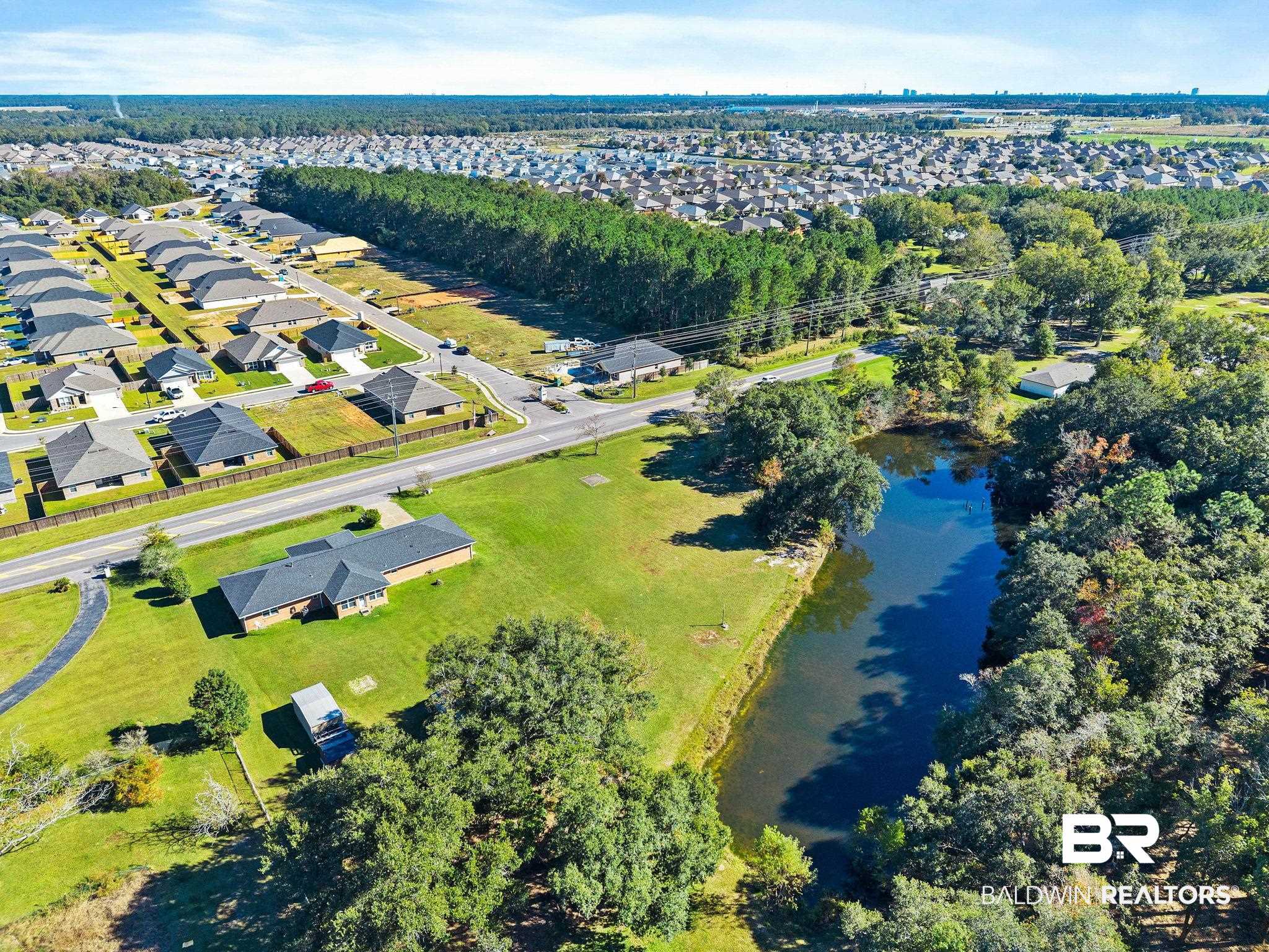 1510 South Juniper Street Foley, AL 36535 - Photo 33 of 36 Aerial view of property and surrounding area with a large body of water and nearby suburban area