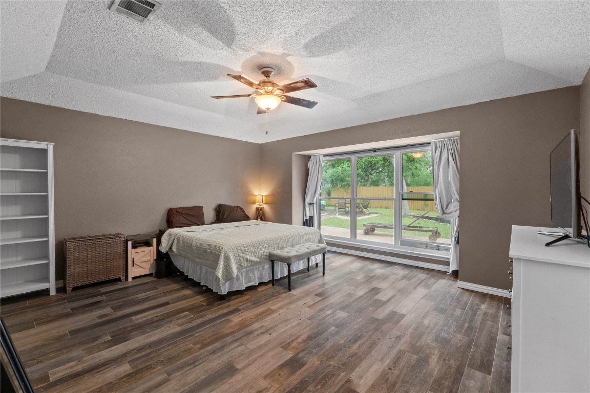 811 Timber Trail Cedar Park, TX 78613 - Photo 21 of 30 a spacious bedroom with a bed and a flat screen tv