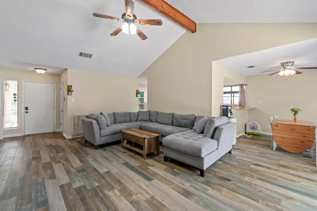 a living room with furniture and wooden floor