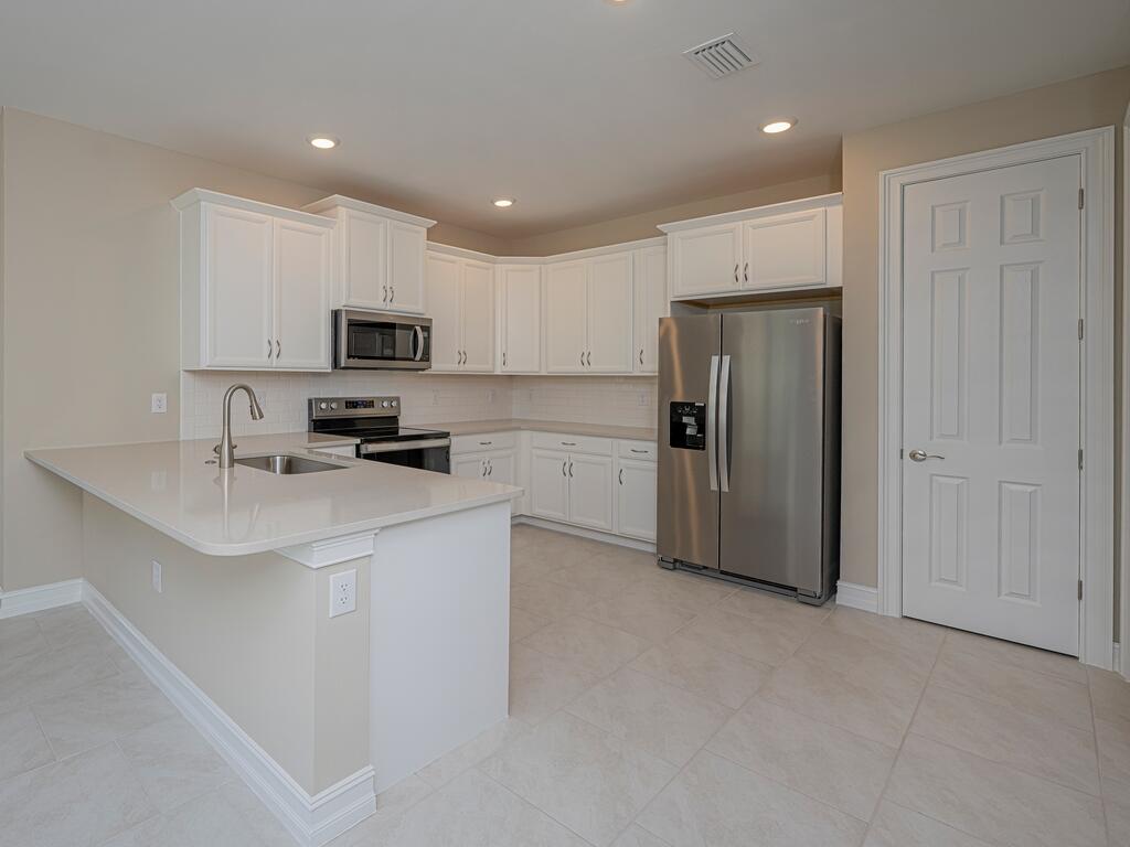 1087 Rolling Brk Lane Naples, FL 34114 - Photo 3 of 33 a kitchen with kitchen island a refrigerator sink and cabinets