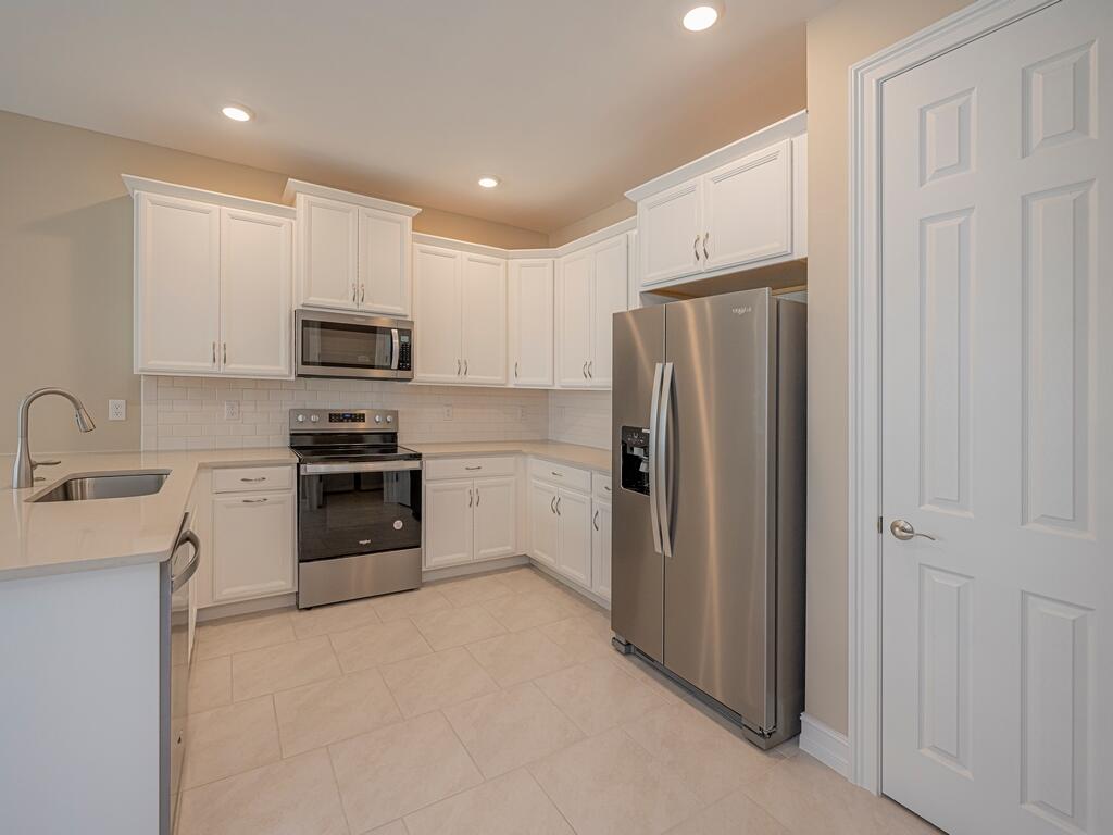 1087 Rolling Brk Lane Naples, FL 34114 - Photo 4 of 33 a kitchen with a refrigerator sink and cabinets