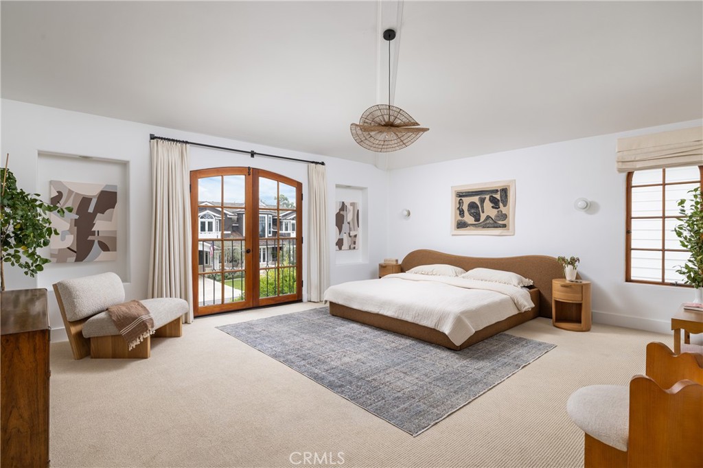 419 Signal Road Newport Beach, CA 92663 - Photo 19 of 32 a spacious bedroom with a bed and a chandelier