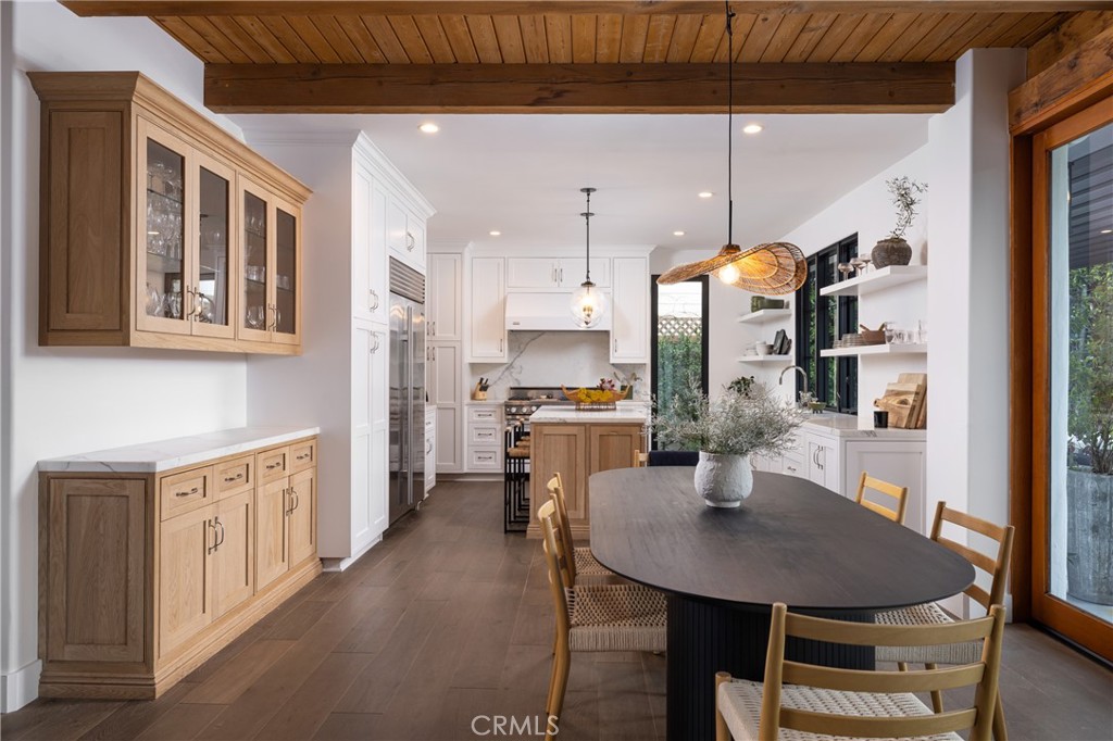 419 Signal Road Newport Beach, CA 92663 - Photo 10 of 32 a kitchen with stainless steel appliances a dining table chairs and a refrigerator