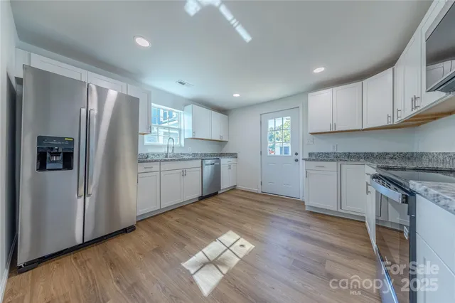 a kitchen with stainless steel appliances granite countertop a refrigerator sink and cabinets