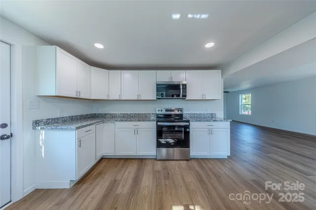 a kitchen with granite countertop wooden floors and stainless steel appliances