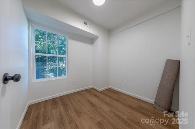 a view of a room with wooden floor and a window