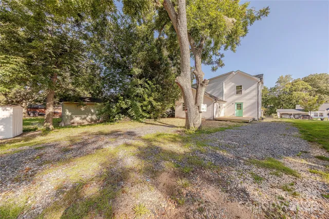 a view of a yard with brick house and a large tree