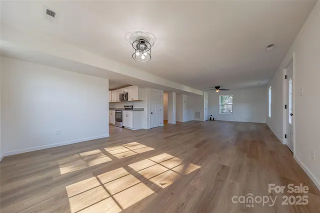 a view of empty room with wooden floor