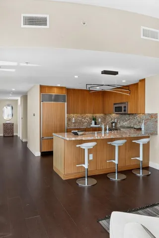 a kitchen with stainless steel appliances granite countertop a sink and a refrigerator