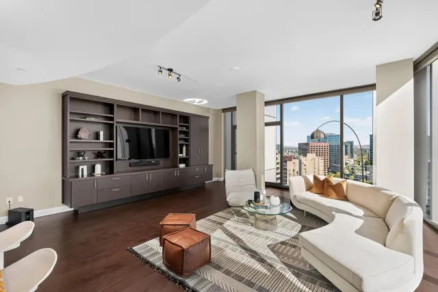 a living room with furniture and floor to ceiling windows
