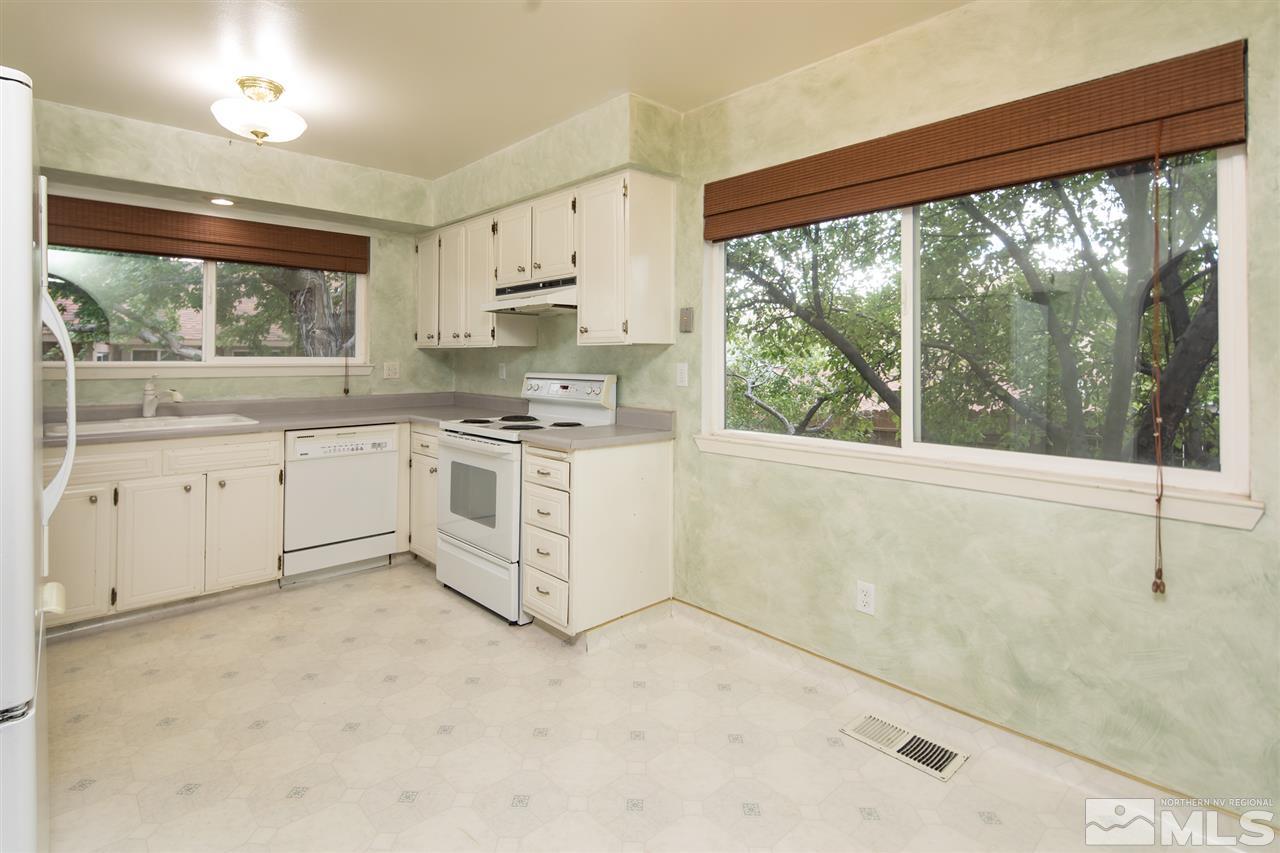 3375 Lookout Place Reno, NV 89503 - Photo 6 of 25 a kitchen with stainless steel appliances granite countertop a stove a sink and white cabinets