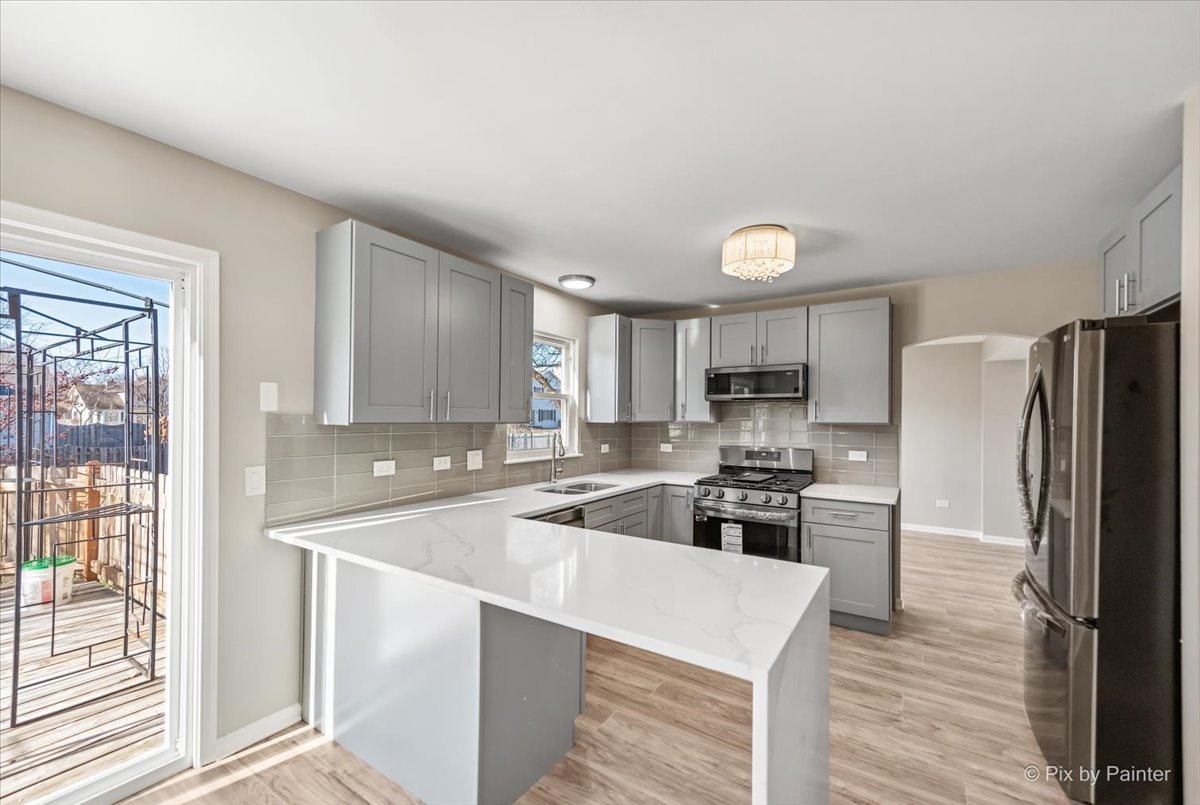 2004 Clematis Drive Algonquin, IL 60102 - Photo 4 of 44 a kitchen with stainless steel appliances granite countertop a refrigerator a stove and a sink with wooden floors