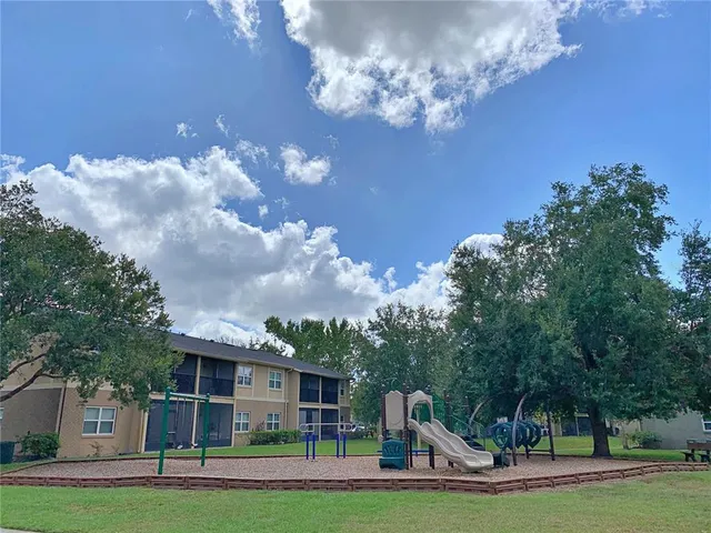 a view of a house with a big yard and large trees