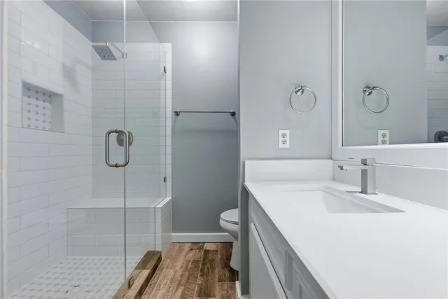 a bathroom with a sink a toilet and shower