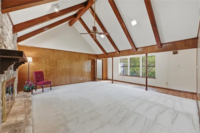 a view of an empty room with wooden floor and windows