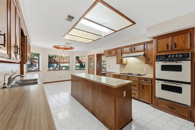 a kitchen with stainless steel appliances granite countertop a stove a sink and a refrigerator